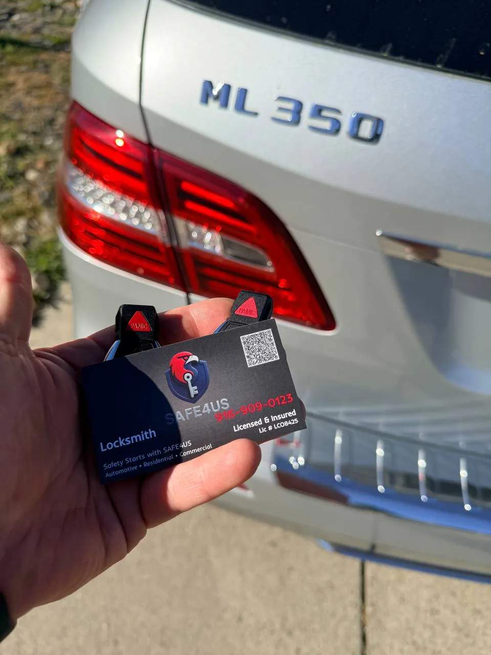 Mercedes-Benz key fob and Safe4us business card shown together after duplicating a spare key