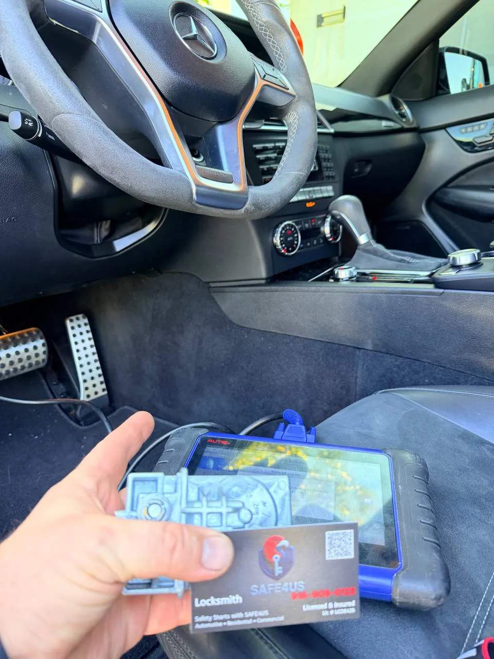 Safe4us technician working inside a Mercedes-Benz cabin with a diagnostic tablet and ignition module