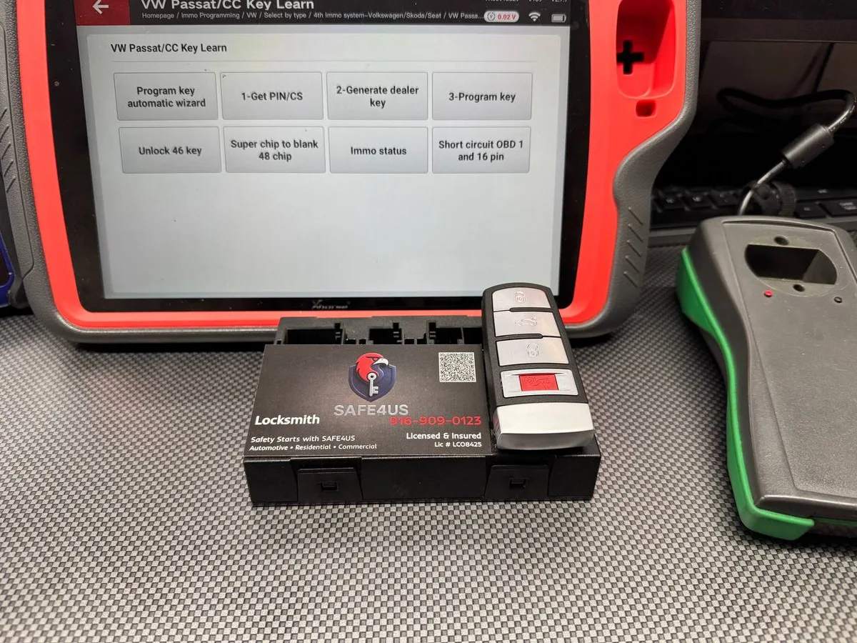 Diagnostic tablet running key-learn software next to a Volkswagen module and key fob